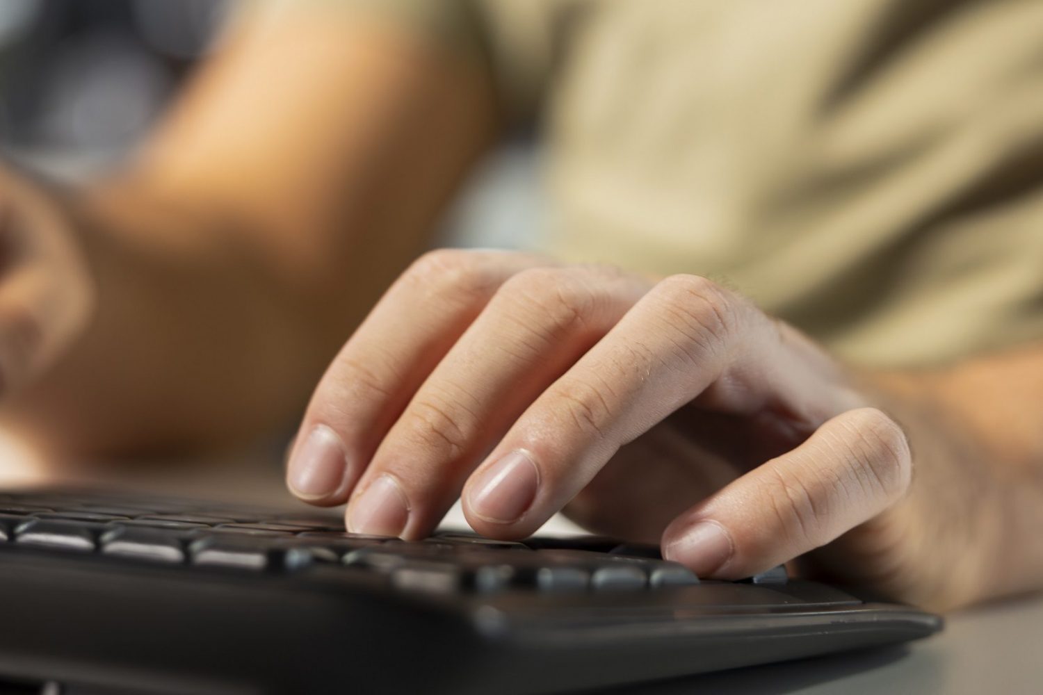 Close up of man at desk typing on keyboard Accountant typing on keyboard, imputing revenue figures on computer in office. Close up of man at desk focused on typing company statistical numbers, working hard to finish job before deadline